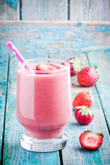 strawberry smoothie in a glass with a straw