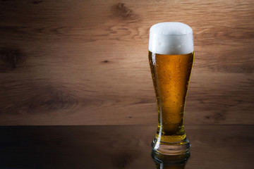 Beer. Gass of beer on wooden background with copyspace