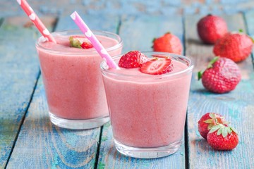 Two glasses of strawberry smoothie with straws
