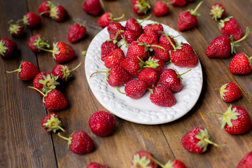 organic fresh sweet strawberries as a seasonal breakfast in the morning right from farmers market on dark wood table background decorated in rustic style
