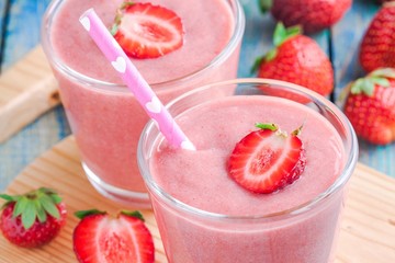Two glasses of strawberry smoothie with straws