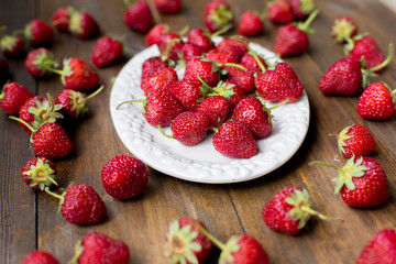 organic fresh sweet strawberries as a seasonal breakfast in the morning right from farmers market on dark wood table background decorated in rustic style
