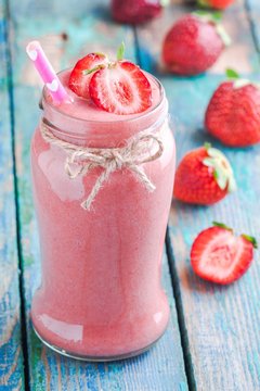 strawberry smoothie in a jar with a straw