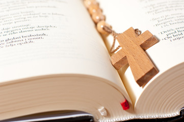 Christian cross necklace on open Bible