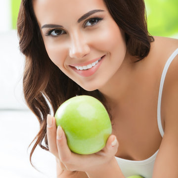 Young smiling woman with green apples