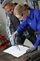 Apprentice in plumbing using compas to draw installation