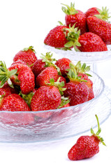 Transparent glass bowl with strawberries on white background