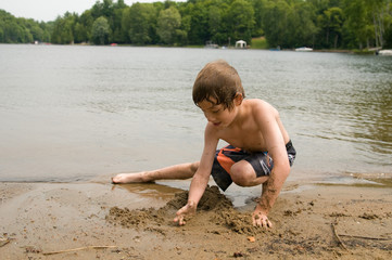 boy playing on a sandy beach in cottage country