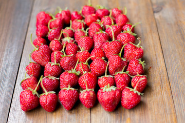 organic fresh sweet strawberries in rows as a seasonal breakfast in the morning right from farmers market on dark wood table background decorated in rustic style