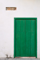 Old green door on white wall
