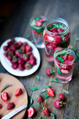 strawberry mint infused water decorated in rustic style on dark wood table background