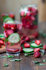 strawberry mint cucumber infused water decorated in rustic style on dark wood table background