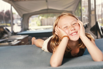 Young girl relaxing on the bed in a tent trailer © michaelcourtney