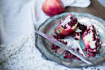 organic pomegranate open cut in half and full one on a wooden dark table background decorated in rustic style