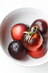 Black tomatoes in a white bowl