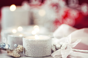 Fototapeta na wymiar Glittery silver candles and glass beaded vintage style Christmas ornaments with selective focus to create holiday themed still life image. 