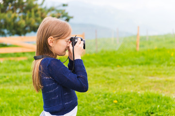 Cute little girl taking pictures with a camera