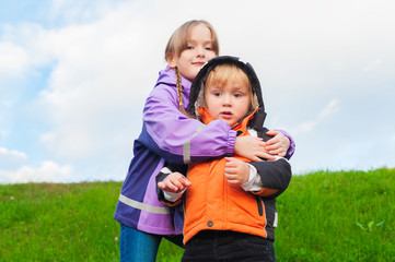 Fototapeta premium Outdoor portrait of two cute kids wearing warm coats