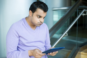 Man frustrated by what he sees on tablet