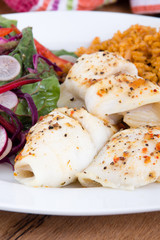 baked sole fish roll with rice and fresh salad dish