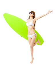 happy young woman running and holding surfboard