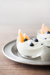 Greek Yogurt & Fruit, blueberries and cantaloupe in glass dessert bowls. 