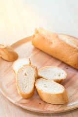 Sliced french bread baguette on wooden plate.Soft focus style