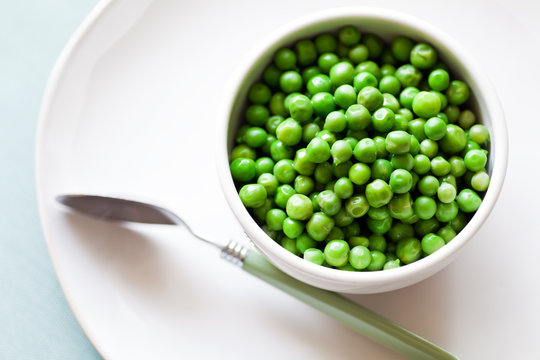 Green Peas in a bowl with spoon taken from above. 