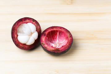 Mangosteen and cross section showing the thick purple skin