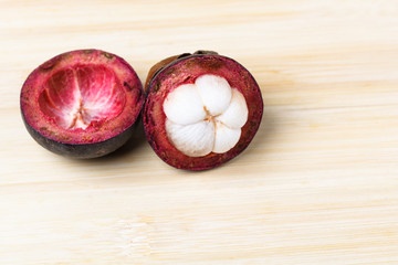 Mangosteen and cross section showing the thick purple skin