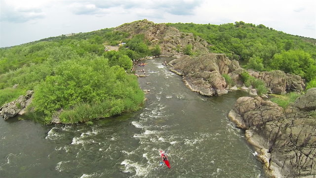 
Red kayak goes down on  rough river. Rafting team, aerial.
