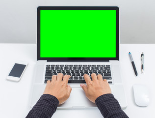 Man hands typing on green screen laptop computer