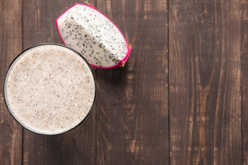 Dragon fruit smoothie on wooden background.