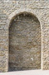 Medieval limestone wall with arch