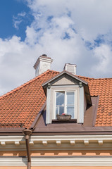 Authentic mansard window in a old style tiled roof