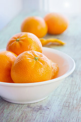Tangerines in white plate on wood table