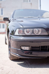 Obraz na płótnie Canvas Closeup photo of black car's headlight