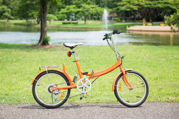 Fototapeta na wymiar orange folding bicycles in park