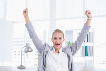 Happy businesswoman with raised arms