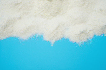 powdered milk on blue background with copy space