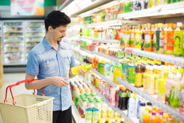 man in a supermarket buying a bottle of juice