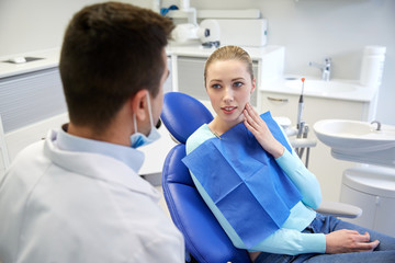 male dentist with woman patient at clinic