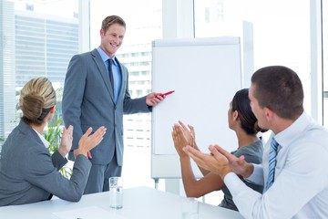 Manager presenting whiteboard to his colleagues