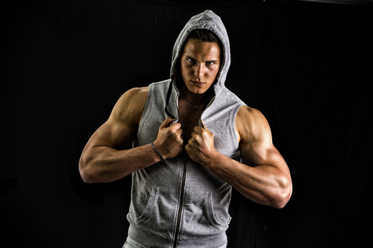 Muscular man with open blue hoodie on bare chest