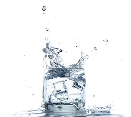 Fototapeta na wymiar Water splashing from glass on white background