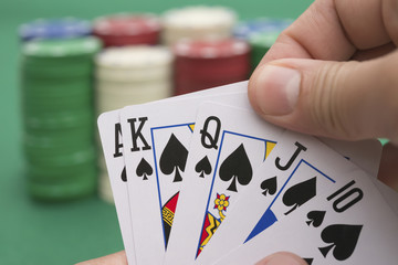 poker player holding 10 to King spade straight flush of pokers, A spade  is coming