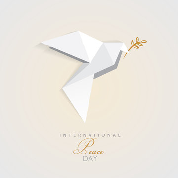 international peace day vector illustration of white origami dove bird with golden olive branch
