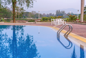 Luxury swimming pool with plam tree in morning