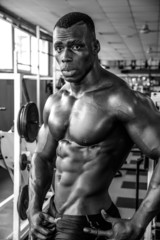 Fototapeta na wymiar Attractive hunky black male bodybuilder in gym