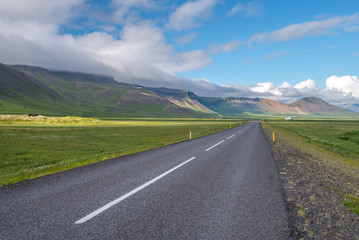 Fototapeta na wymiar Icelandic paved road next to mountains.